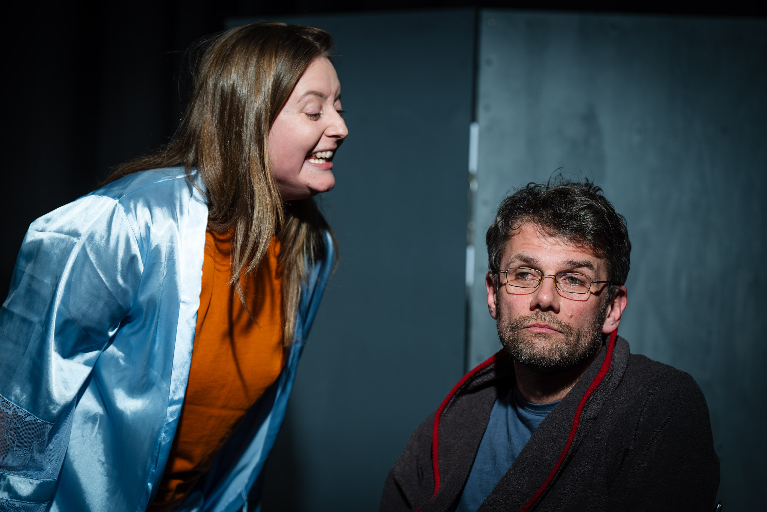 A woman in a blue robe yells at a man in a robe.