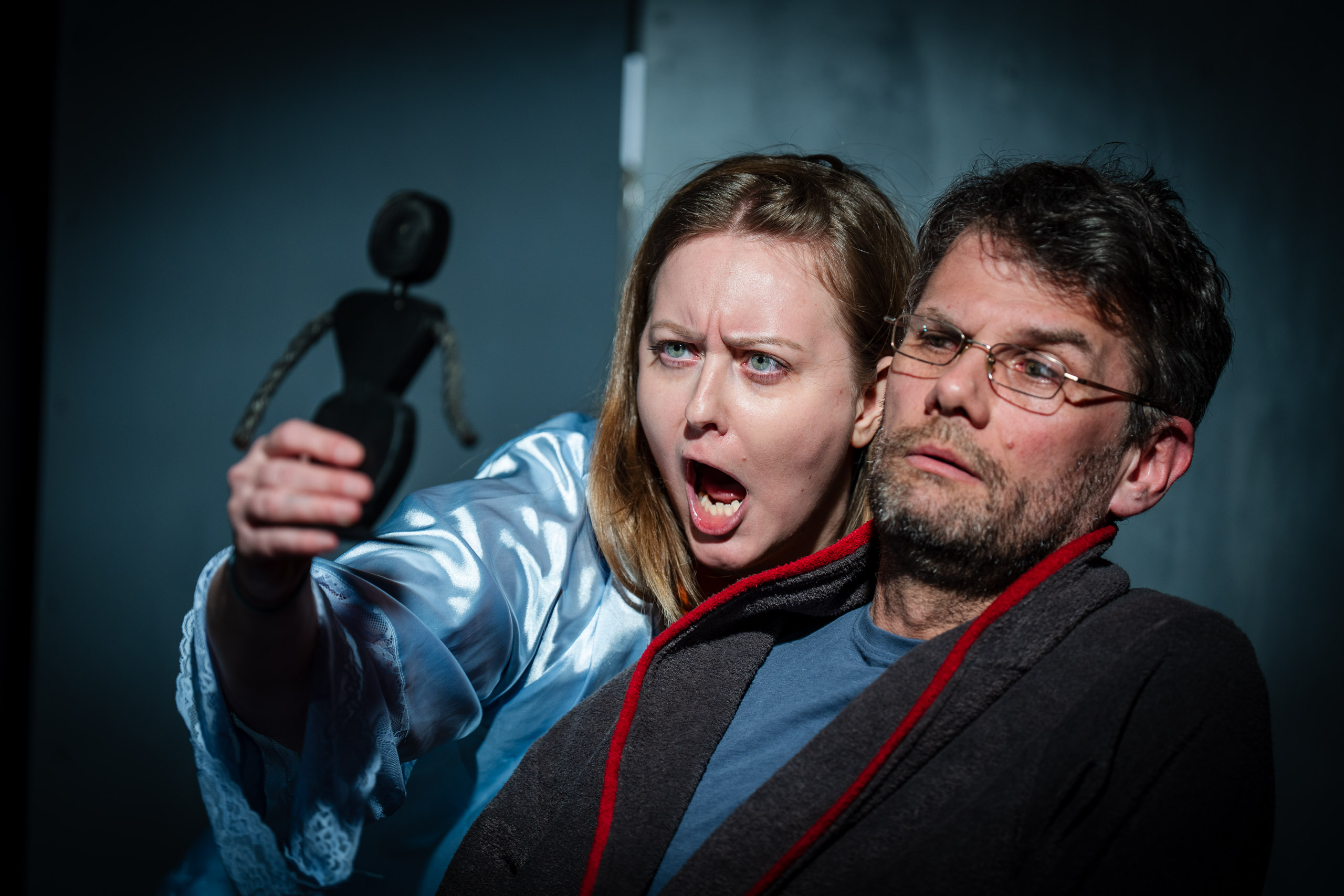 A woman screams at a man while holding a doll.