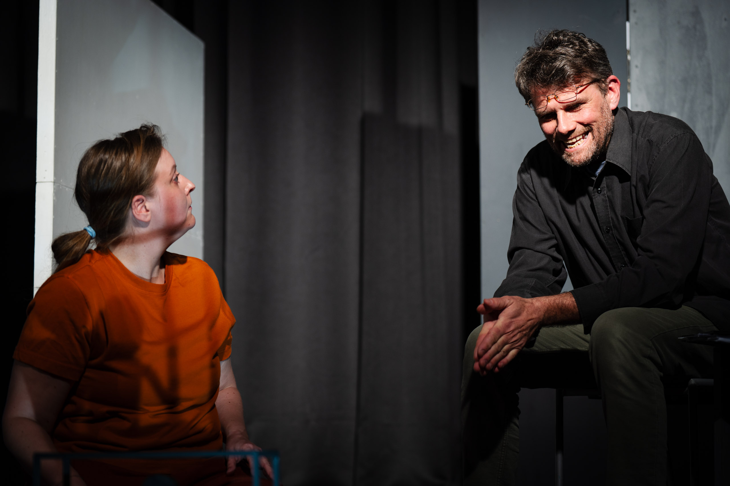 A man and a woman are on stage, possibly during a play or perfor