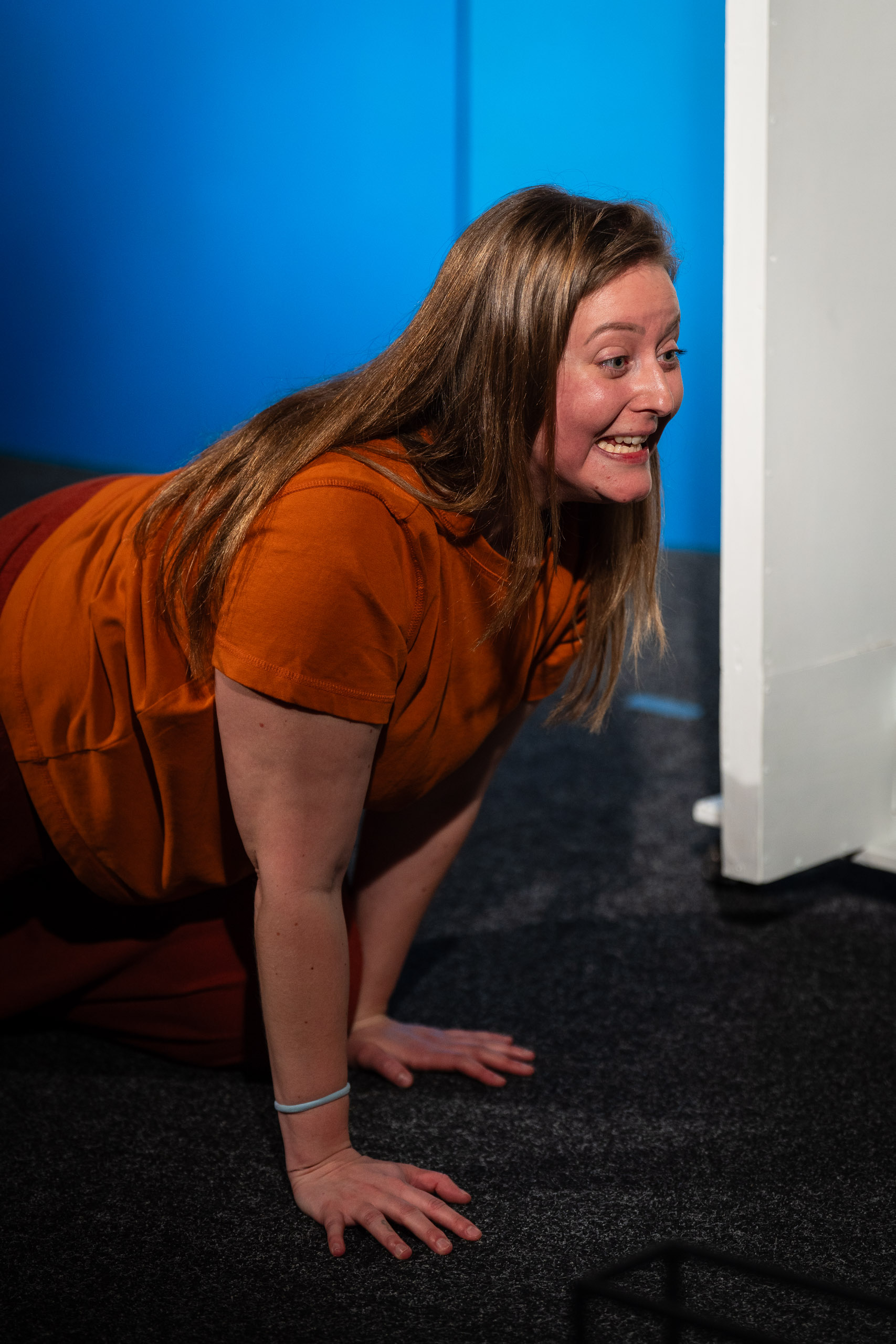 A woman on her hands and knees, looking to the side with a surpr