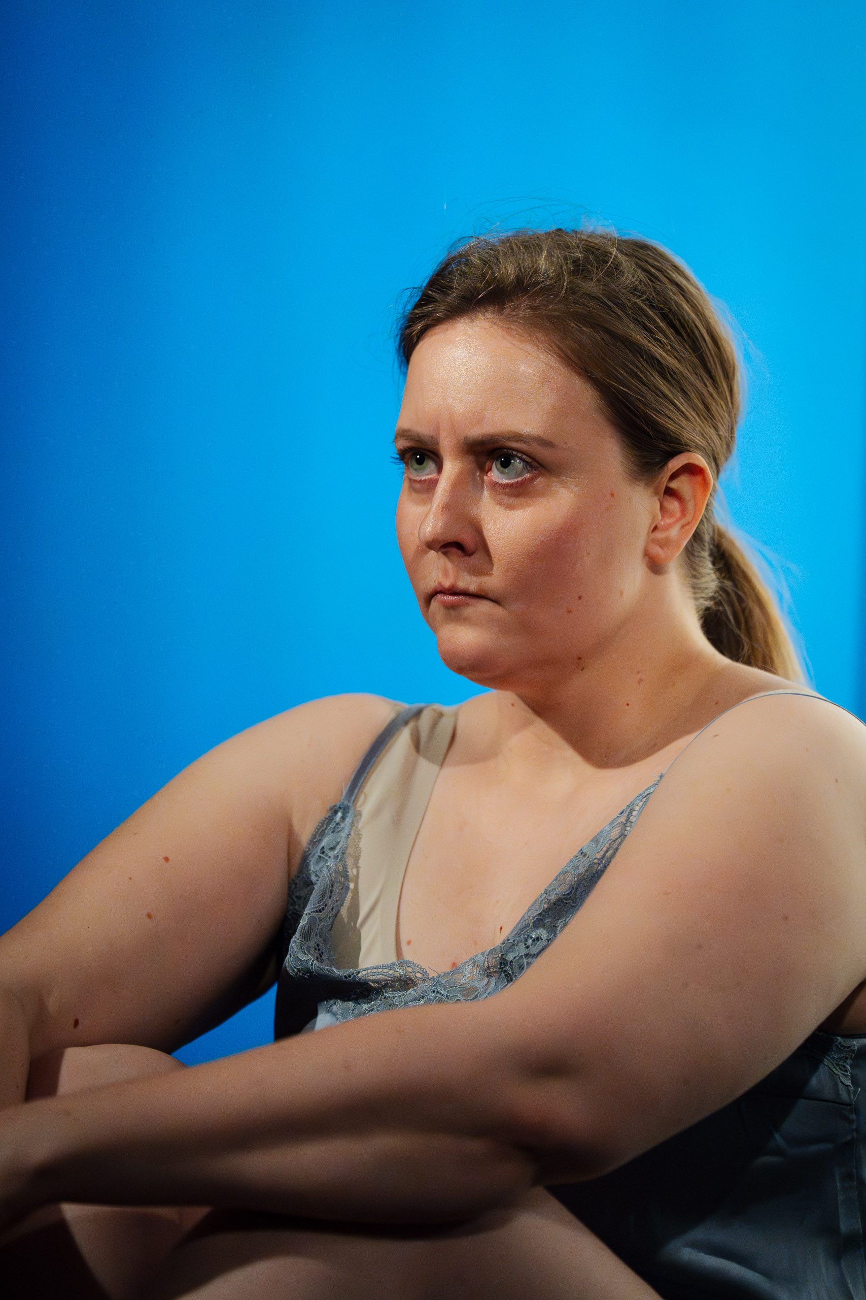 A woman with a pensive expression looks away from the camera.