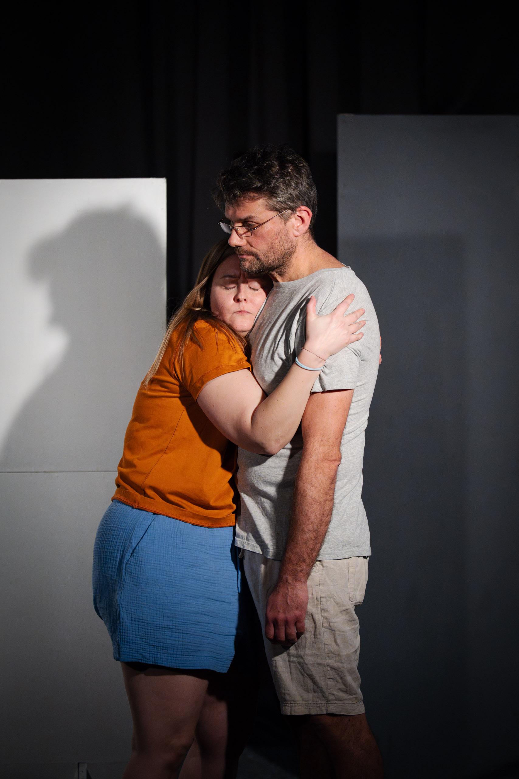 A woman embraces a man, finding solace and comfort in his arms.