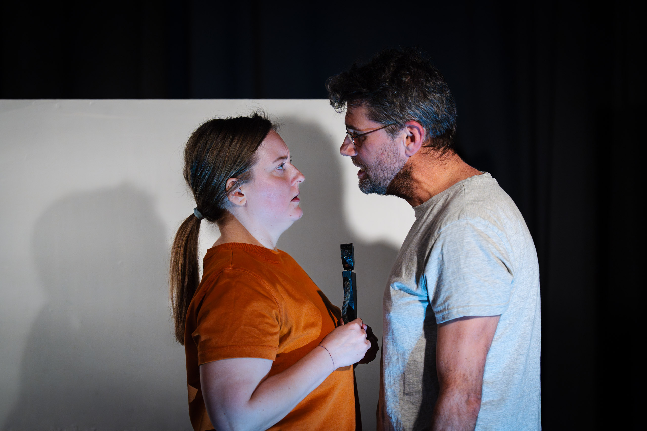 A man and a woman confront each other intensely, with the woman
