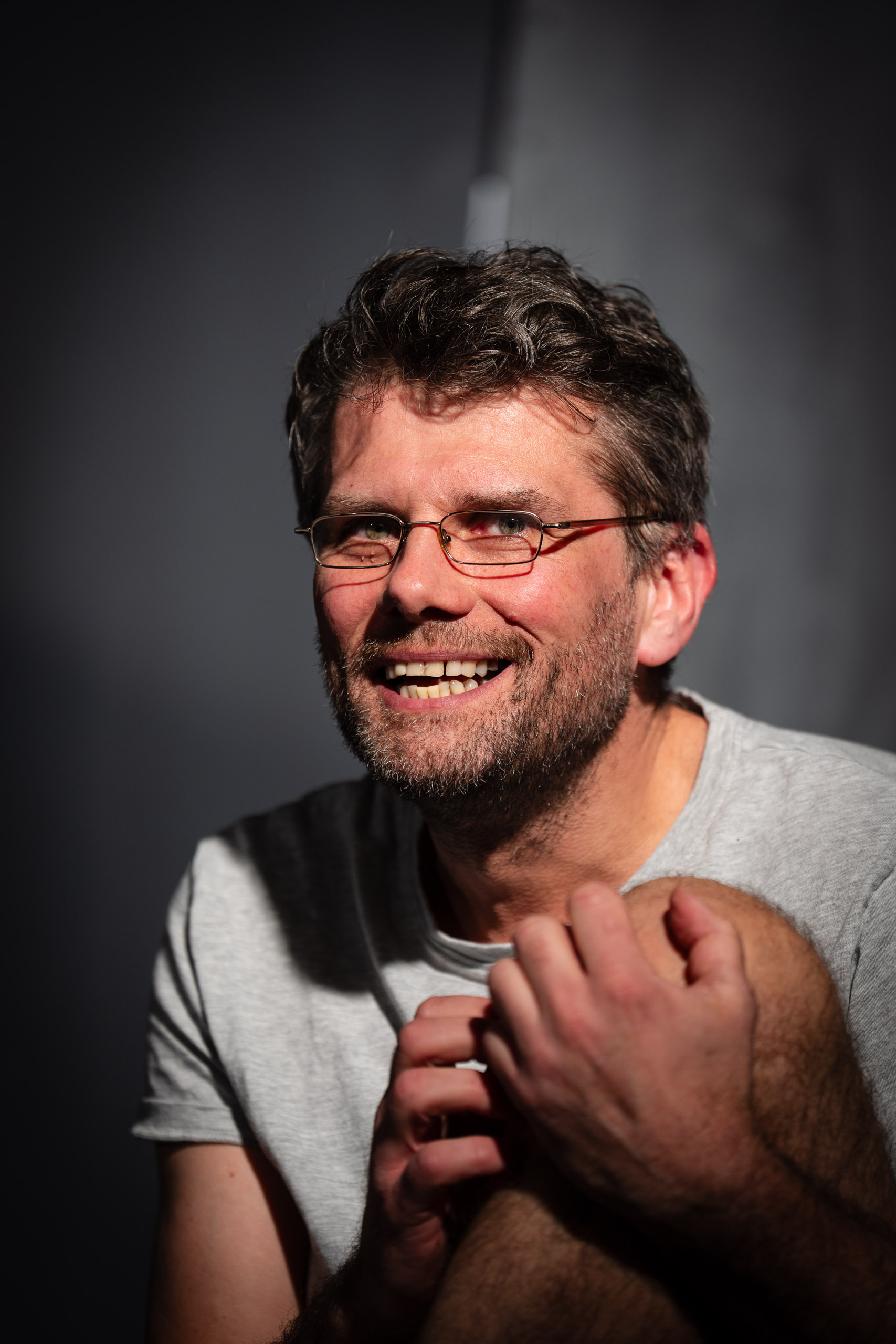A man with glasses and a beard smiles at the camera.